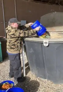 Aladdin Dining Services' Jonathan Steen empties a bucket of raw food waste into the composter.