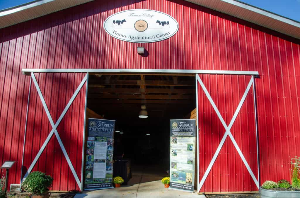 Titmus red barn close ups with door wide open, white sign above door, and tall banners beside doors about agrictulture programs