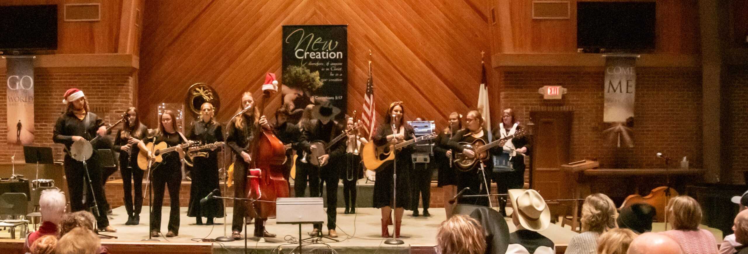 Orchestra Appalachia in black outfits with gold trim playing stringboard instruments in Vaughn Chapel at Ferrum College