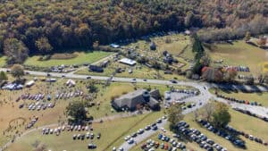 aerial view of college campus and farm museum with folklife festival crowd and fall trees