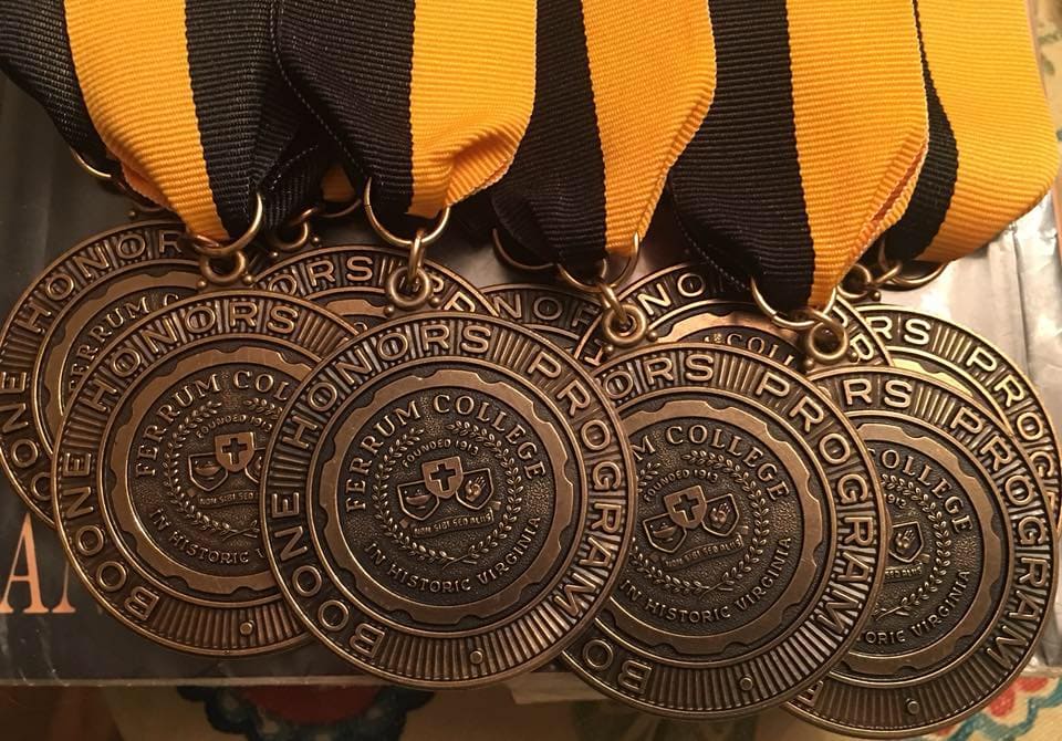 Photo of a group of Ferrum College Boone Honor Program bronze medallions hanging from the ends of gold and black ribbons