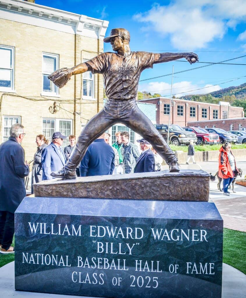 Statue of Billy Wagner pitching in baseball in downtown of. Tazewell, with onlookers and buildings in back.