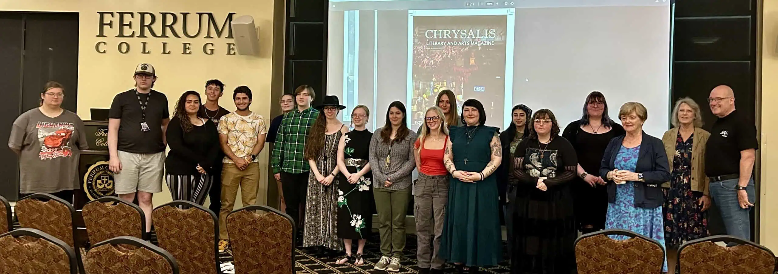 Contributors and staff of Chrysalis Magazine in Blue Ridge Mountain Room in front of screen April 2025
