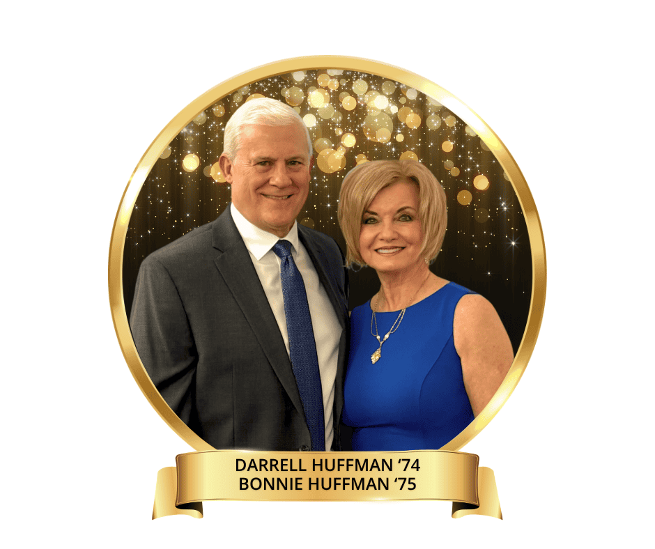 A headshot photo of Darrell '74 and Bonnie Huffman '75. Darrell is wearing a grey suit with a navy blue tie. Bonnie is wearing a blue dress and a gold necklace. The back drop behine them is black and gold.
