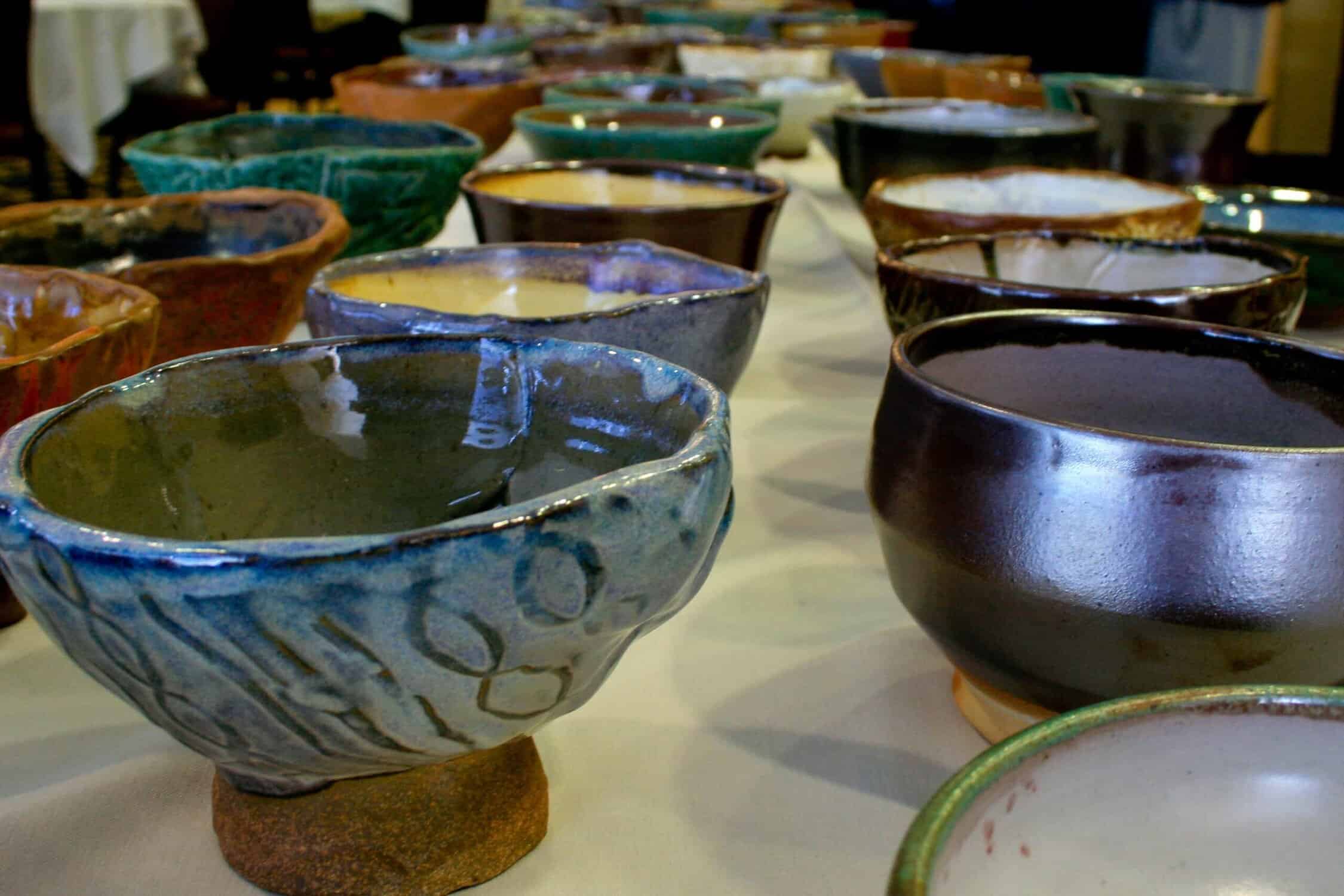 Hand crafted pottery bowls are displayed on the table for the annual Empty Bowls event