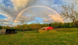 Titmus farm sits to the right with a rainbow and partly skies above