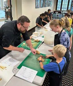 Homeschool students shown interracting with members of the Ferrum College community in a cooking class.
