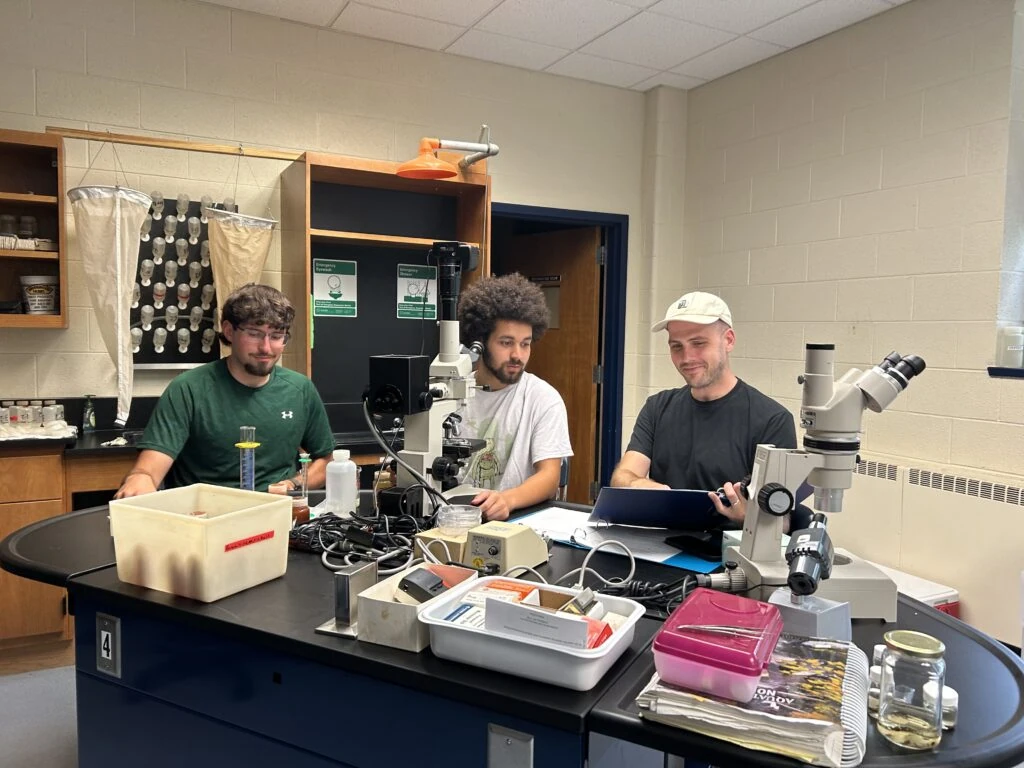 Three student interns at a lab table in Garber Hall at Ferrum College checking samples for the Smith Mountain Lake Water Quality Program in July 2025