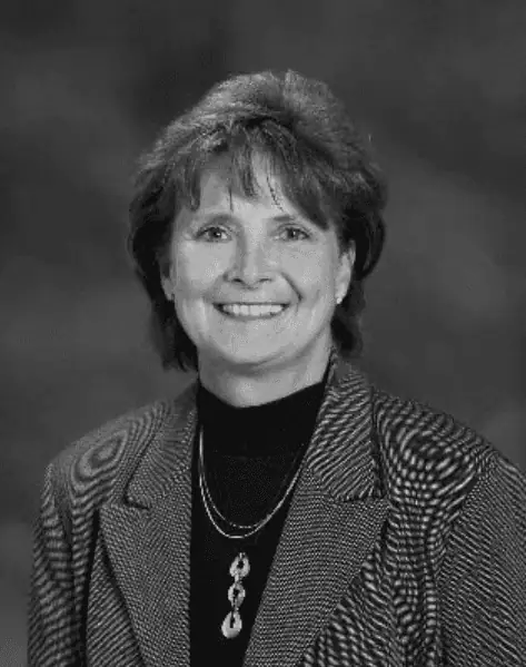 Phyllis Karavatakis black and white headshot in dark suit