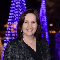 Headshot of Kim in professional clothing.