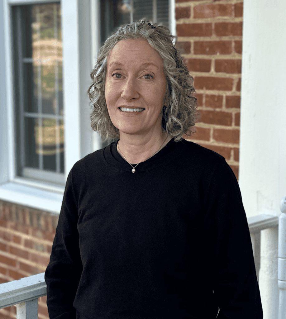 Headshot of Lori Sliwa on the front porch of John Wesley Hall