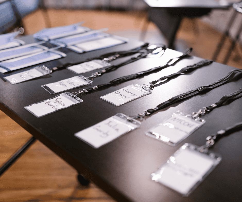 Image of conference badges laid out on a registration table.