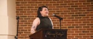 Student in black outfit at Ferrum College podium in front of brick wall