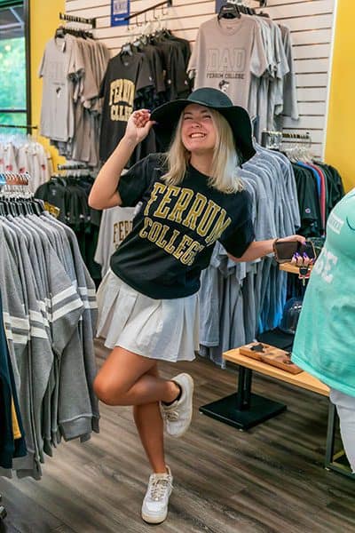 female student in the Campus Store wearing a Ferrum College shirt and white skirt