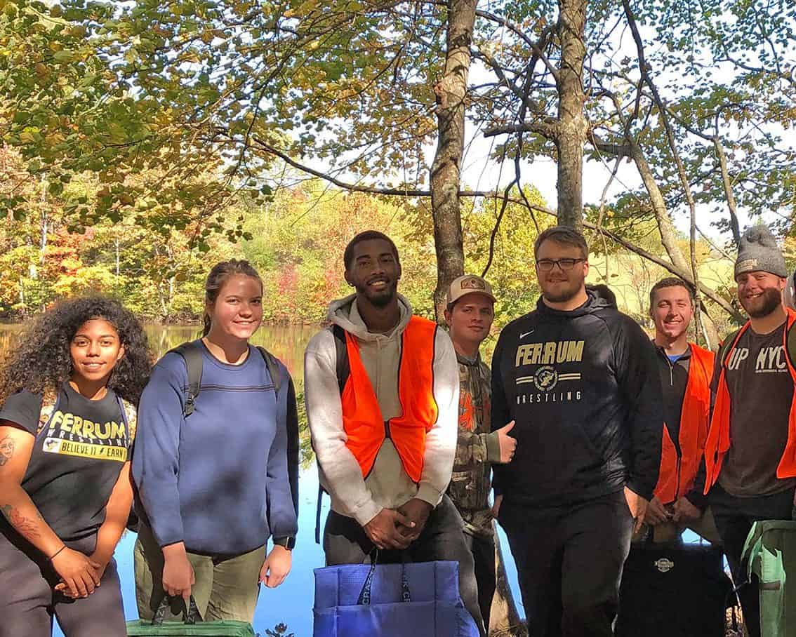 students stand in front of a lake finishing a hike with norton outdoors