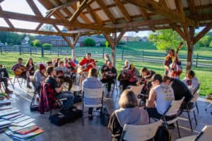 People sit around in chairs and play music and sing songs