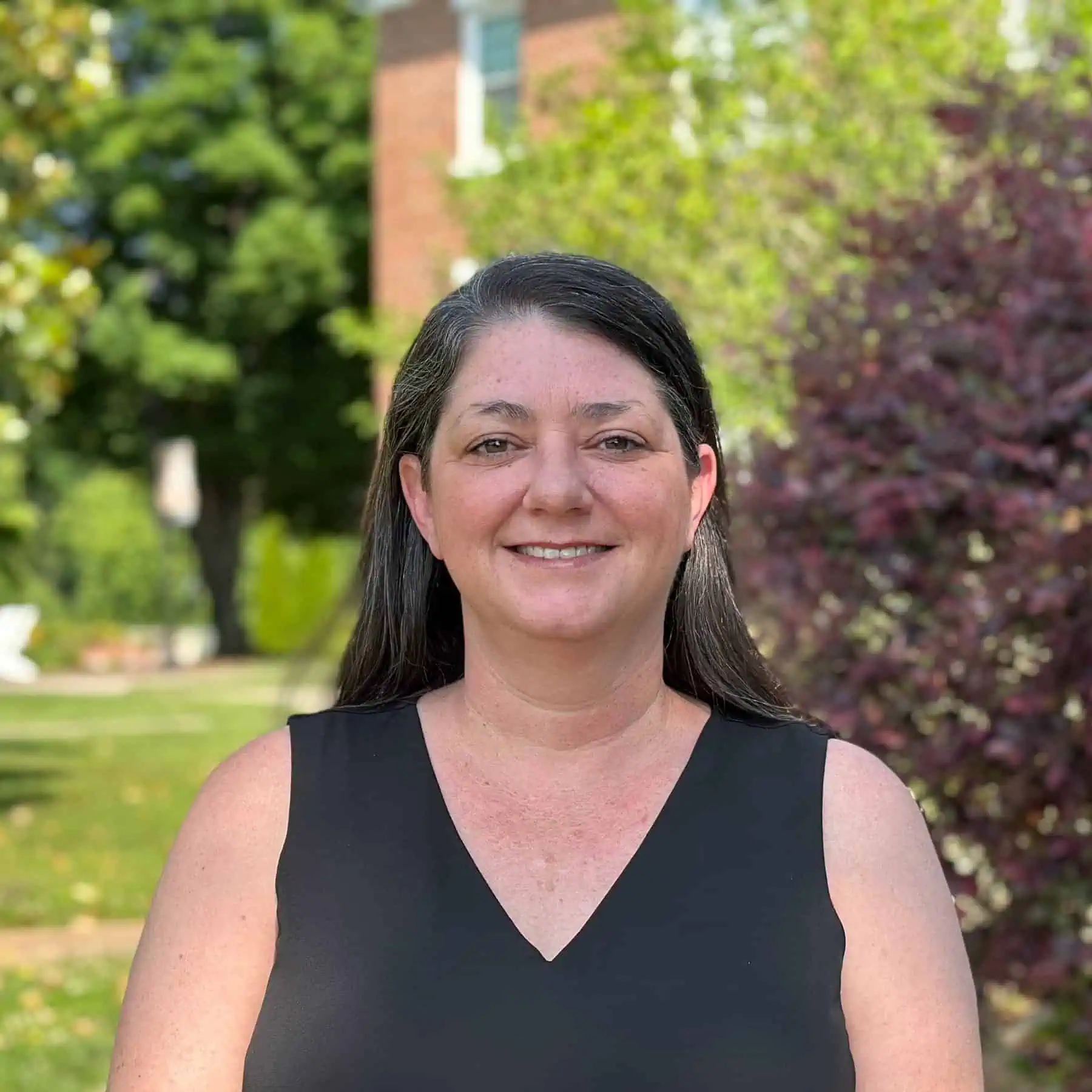 The photo is of Erin Carter wearing a black tank top taken outside on the Ferrum College campus on a pretty summer day