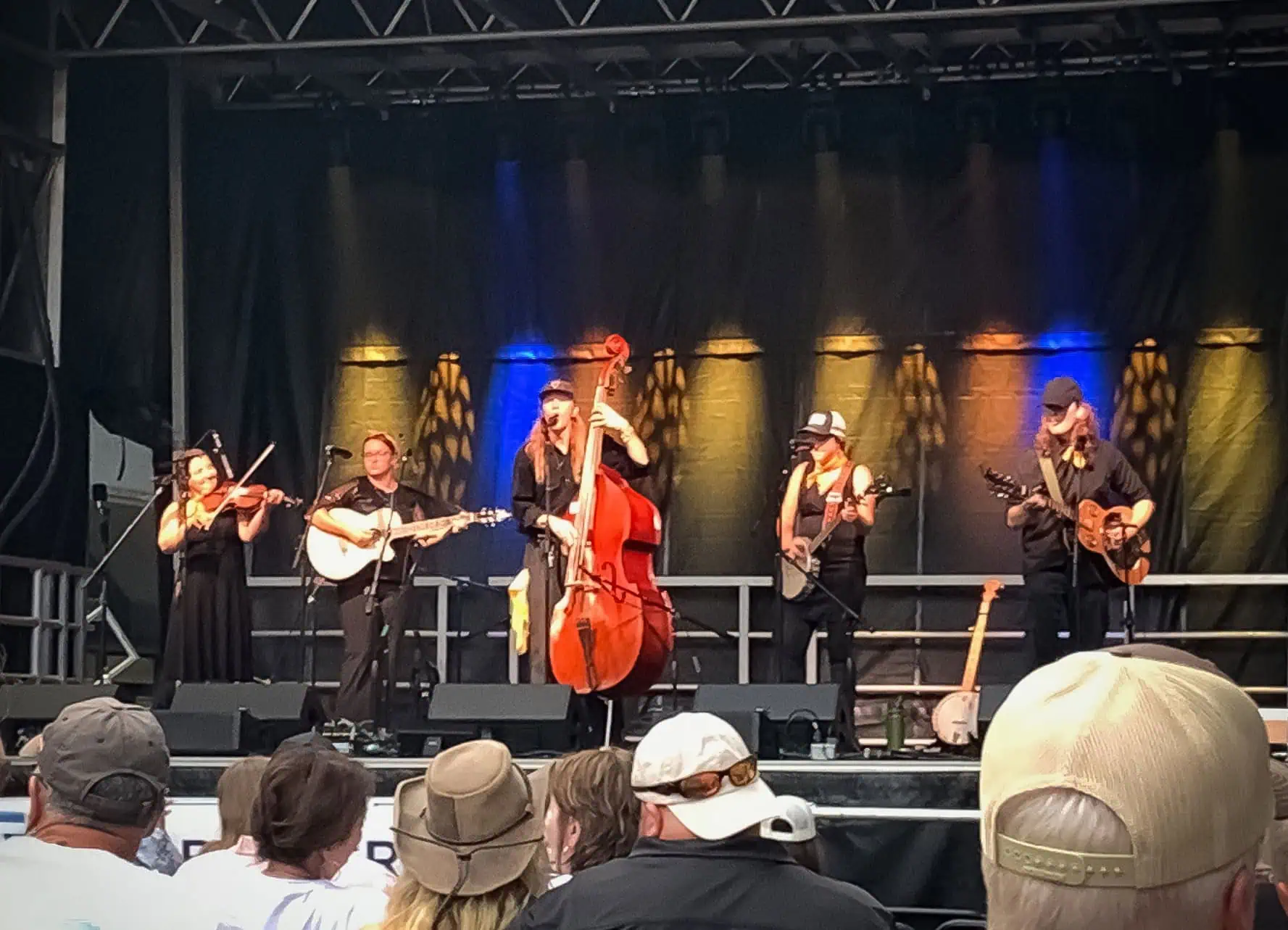 Ferrum College Orchestra Appalachia members playing bluegrass instruments on a stage with an audience in the foreground