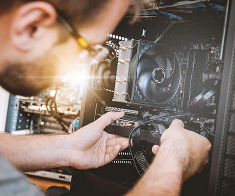 male inspecting the inside of a computer monitor