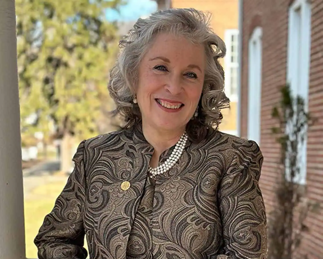 President Mirta Martin standing outside of John Wesley Hall.