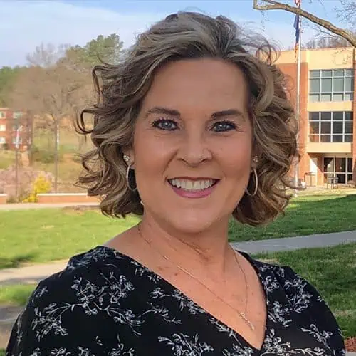 Headshot of Brenda Martin in black shirt in front of Stanley Library.