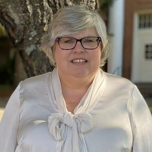 martha haley in white top in glasses in front of a tree for staff photo