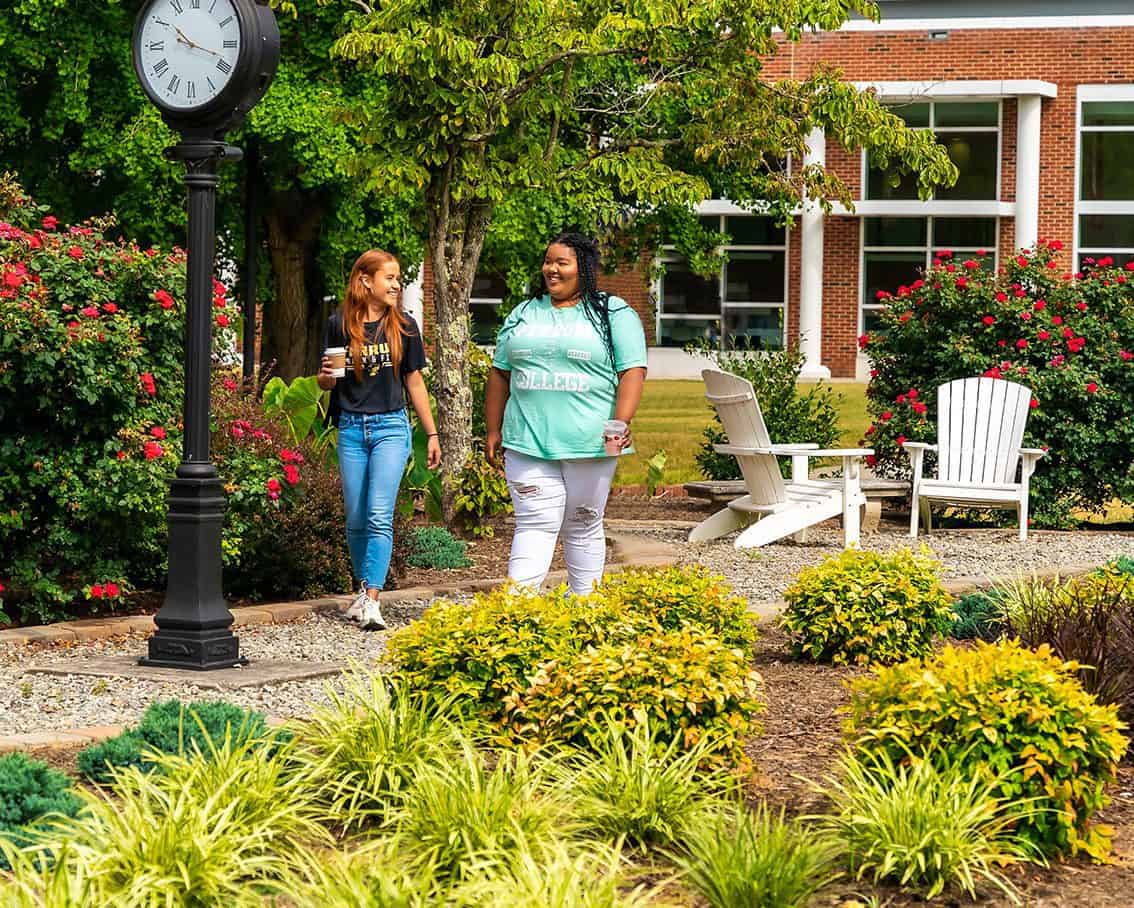 Two female students walking on campus.