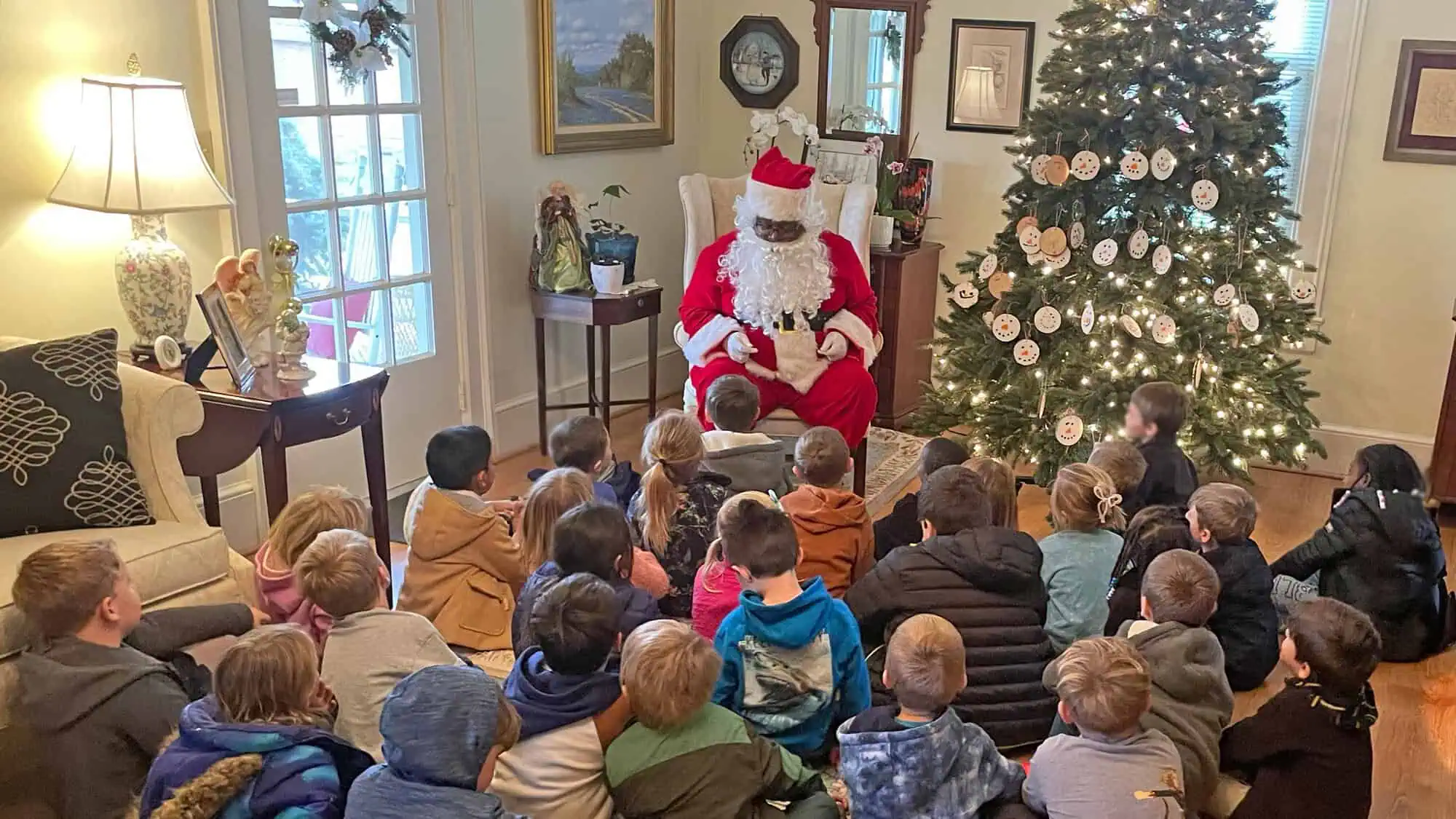 Santa visiting with Ferrum Elementary school children during tree lighting in Stratton House living room