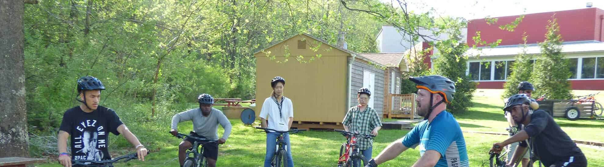 Bicyclists outside brown and ride/white buildings of fitness center